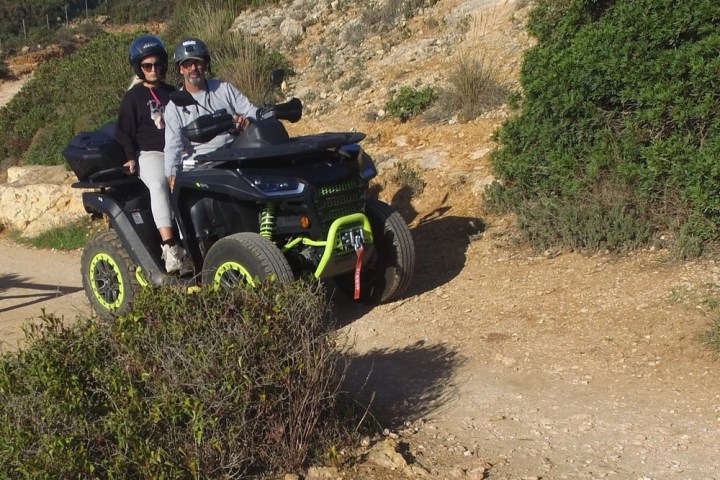 a man riding a motorcycle down a dirt road