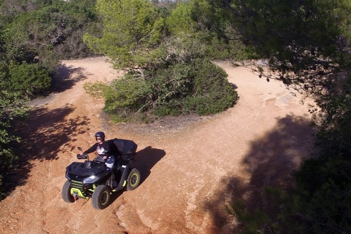 a man riding a motorcycle down a dirt road