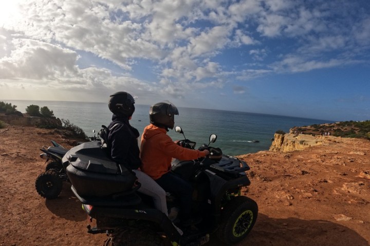 a man riding a motorcycle down a dirt road