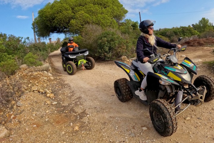 a man riding a motorcycle down a dirt road