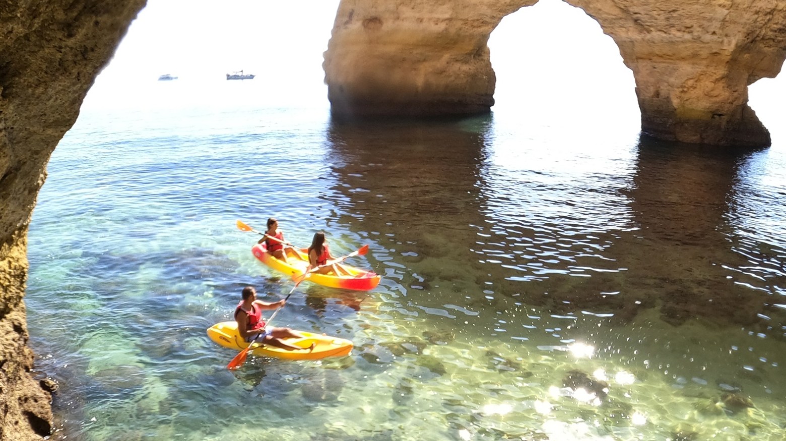 a group of people on a rock in the water