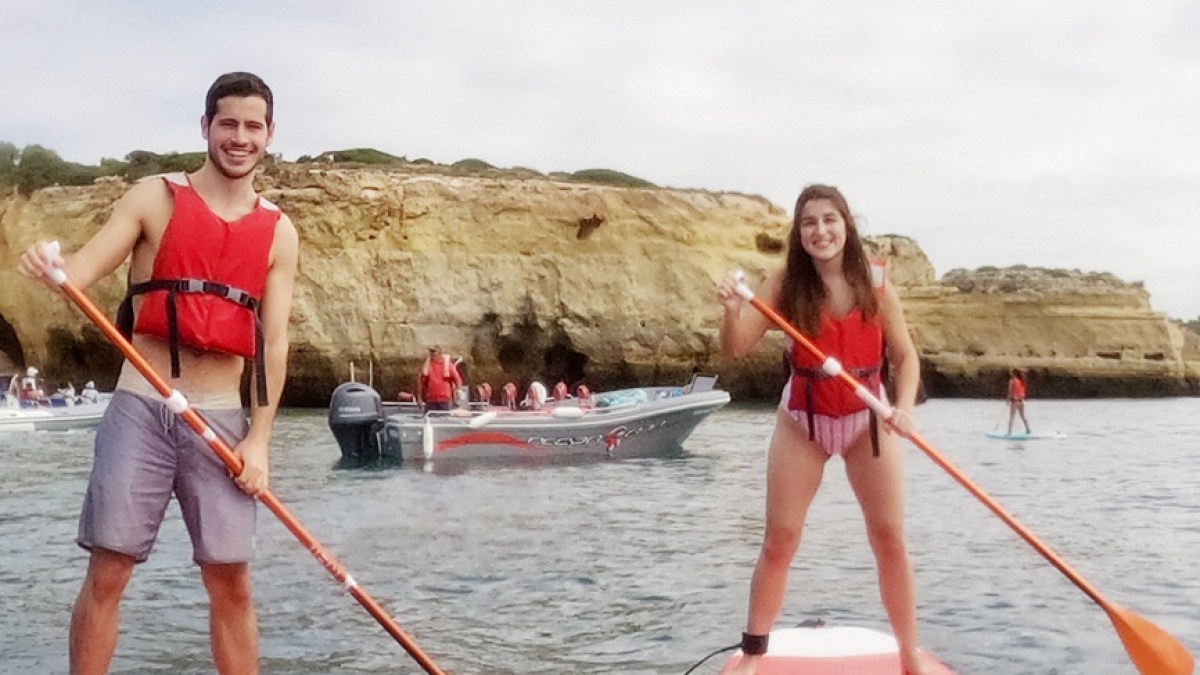 a group of people riding on the back of a boat in the water